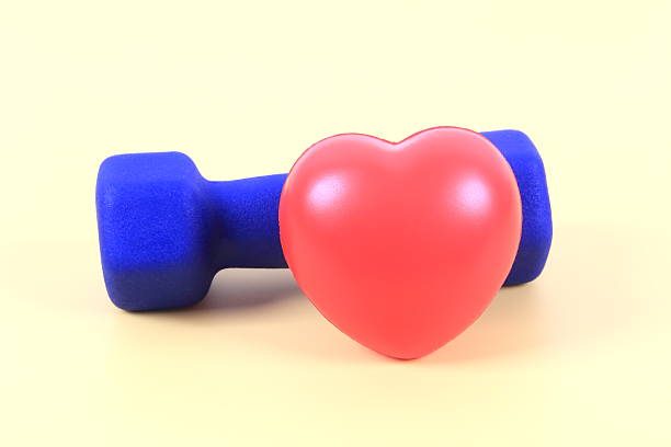 Blue dumbbell and red heart on yellow background