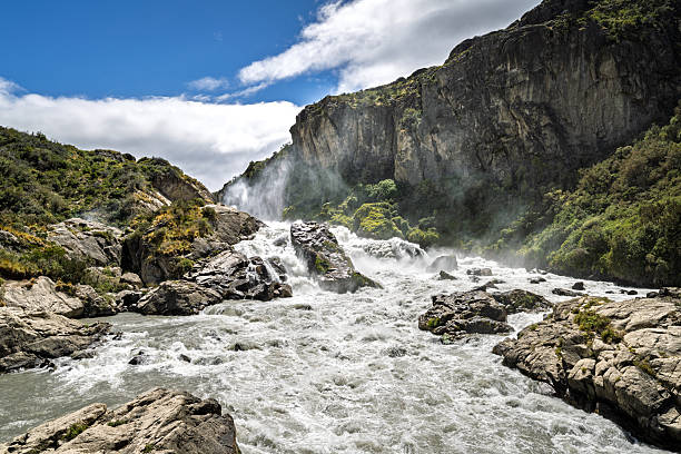 Powerful river rapids and waterfall at Salto Ibáñez in Chilean Patagonia. Fast flowing water surrounded by rocky terrain and mountains highlights the wild landscapes found along the Carretera Austral.