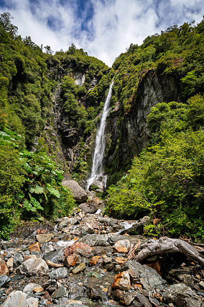 Mountain waterfall cascading through dense green forest in Chilean Patagonia. Remote wilderness landscape typical of the Carretera Austral region, ideal for nature and adventure travel concepts.