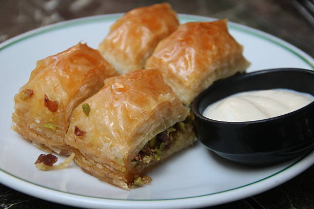 Plate of Four Traditional Turkish Baklavas with a Side of White Cream