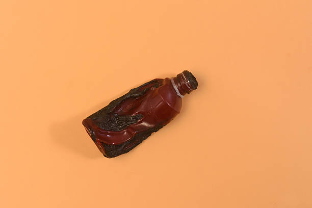 a burnt red plastic syrup bottle on an orange background