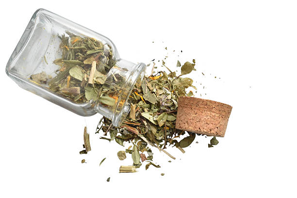 Dry leaves of fragrant herbal tea in a square bottle isolated on white background.