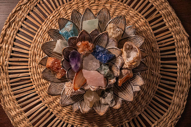 Top view of a decorative bowl filled with colorful crystals and natural stones arranged on a woven surface.