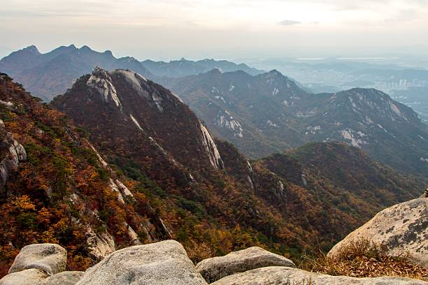 A steep hiking trail climbs along a rocky mountainside surrounded by colorful autumn forest, symbolizing outdoor adventure, exploration, and the journey through nature.