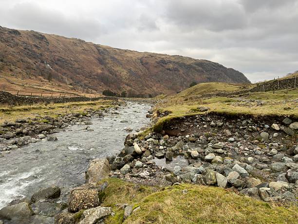 The River Derwent passing through Seathwaite Valley on a grey, overcast winter's day in the Lake District
