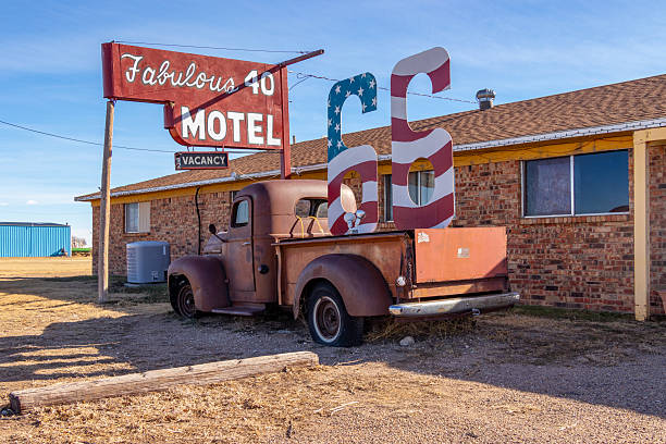 A  roadside motel with vintage signage and an old pickup truck is seen along historic Route 66 in Adrian, Texas.