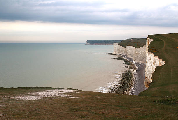 This is one of Britain's most beautiful and unspoiled coastlines. Here, the dramatic chalk cliffs of the South Downs meet the sea. The Seven Sisters are a truly iconic landmark. The Country Park area covers 280 hectares of cliffs, a winding river valley, and meadowland. These cliffs are the result of thousands of years of erosion from the sea, harsh weather, and the constant freezing and thawing of winter. The coastline is constantly changing and moving inland as the cliffs drop down to the beach. As a result, the cliffs are receding by about 30 to 40 cm per year on average. And erosion is currently creating an eighth peak...
