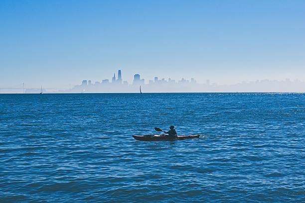 Sausalito California - USA, October 21, 2205. Kayaker paddles San Francisco Bay with the city skyline beyond. Nature and city environment just offshore Sausalito California.