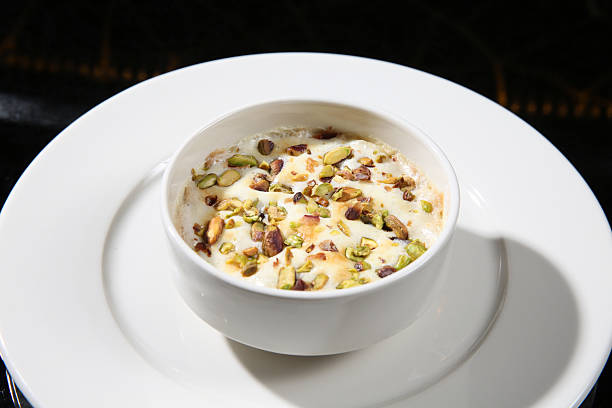 Umm ali traditional dessert with nuts served in ceramic bowl.