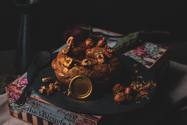 Chocolate dessert pastry with caramelized nut topping photographed in soft dramatic lighting with vintage styling.