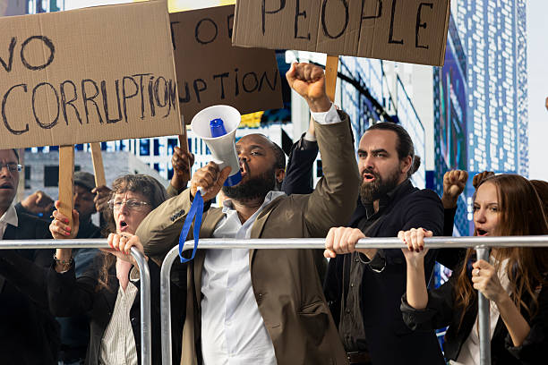 Large crowd of diverse protesters using megaphone and fighting against corruption government, having posters with messages like stop corruption and equal rights during a non-violent demonstration.