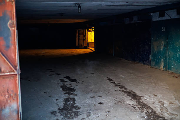 Atmospheric View of a Dark Garage Workshop with Warm Interior Light, Rustic Industrial Workspace and Vintage Storage Room with Work Tools and Clothes