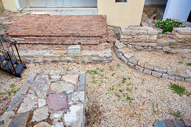 Ancient stone and brick archaeological site with ruins and gravel pathway.