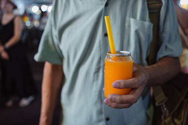 A plastic cup with bubble tea is in the woman's hand, close-up