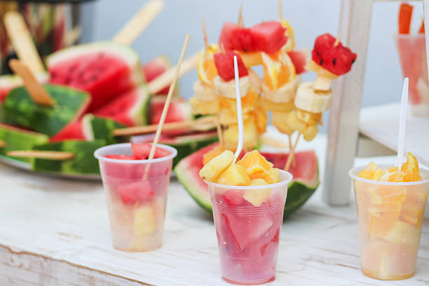 Serving refreshing fruit skewers and cups with watermelon, orange, and banana