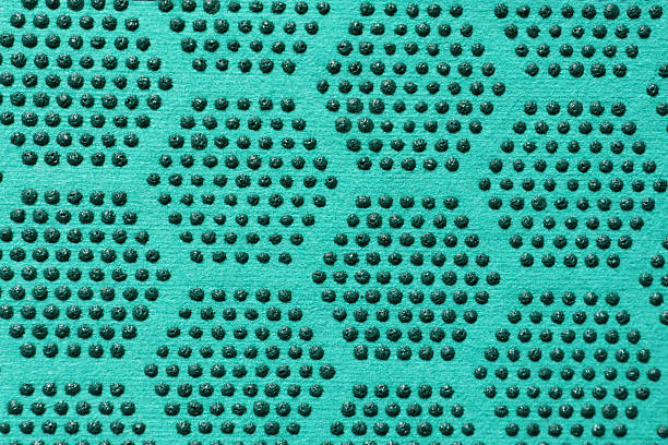 Teal surface with a grid of raised green dots forming a repeating textured pattern