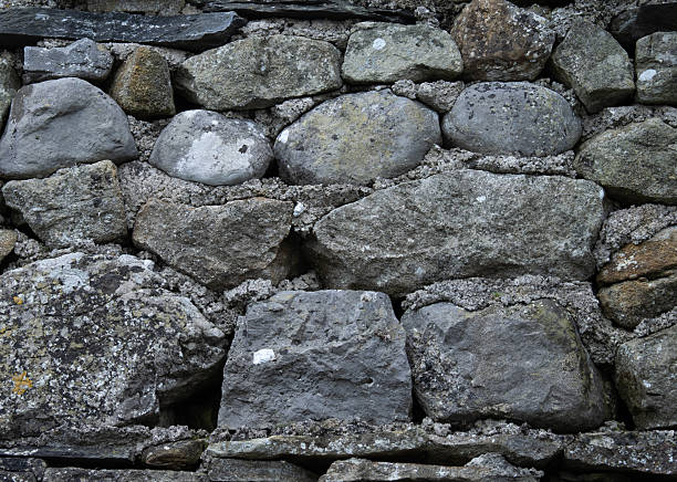 Grungy stone masonry forming a rough background surface.