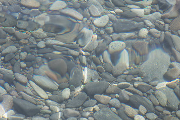 Stones pebbles in the clear sea water.
