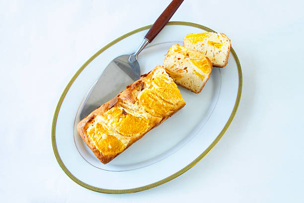 Freshly baked orange pound cake with white background.