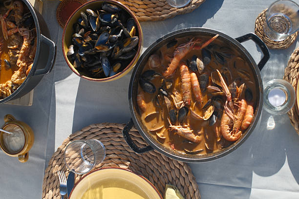A high-resolution photo of assorted fresh seafood including prawns, scampi (langoustines), mussels, and clams. The ingredients are presented raw and arranged naturally, ideal for themes like seafood cuisine, fresh ingredients, Mediterranean diet, and coastal cooking.