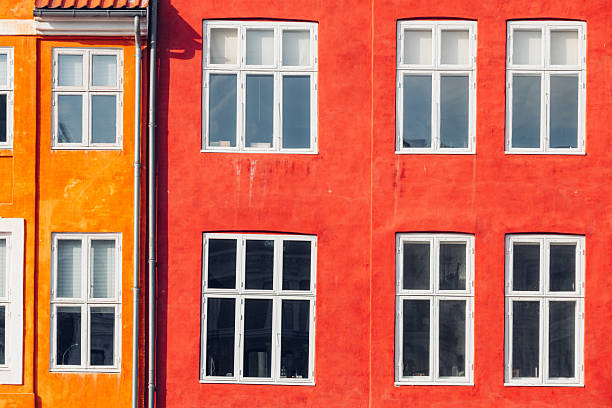 Brightly colored residential facades line Copenhagen streets, showcasing traditional architecture and distinctive Scandinavian design. The close perspective highlights windows, textures, and symmetry, creating a strong visual identity. These images represent urban charm, heritage, and the everyday beauty of city living.