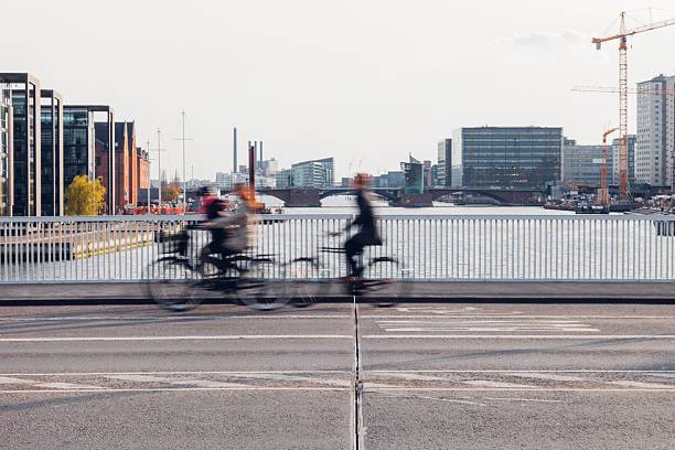 Cyclists ride through Copenhagen streets as part of everyday transportation, highlighting the city’s strong cycling culture. Motion blur and wide urban spaces communicate speed, freedom, and sustainability. The visuals represent eco-friendly travel, healthy lifestyles, and modern European urban planning focused on people rather than cars.