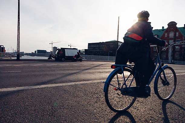 Daily life unfolds in Copenhagen as people walk, cycle, and commute through the city. Motion blur emphasizes the rhythm of urban living, with pedestrians and cyclists moving past historic architecture, bridges, and streets. The scene reflects sustainable transport, active lifestyles, and the calm efficiency of a modern European capital where movement is constant but unhurried.