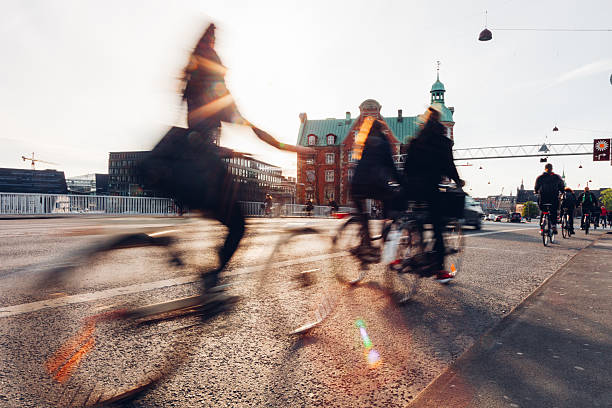 Cyclists ride through Copenhagen streets as part of everyday transportation, highlighting the city’s strong cycling culture. Motion blur and wide urban spaces communicate speed, freedom, and sustainability. The visuals represent eco-friendly travel, healthy lifestyles, and modern European urban planning focused on people rather than cars.