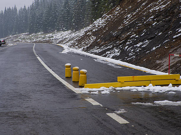Winter snow hangs on the Glenwood Canyon walls and covers the ice filled Colorado River with a long line of traffic on west bound Interstate 70.