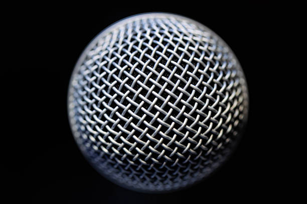 Unrecognizable person holding a microphone to the viewer, ready for the stage