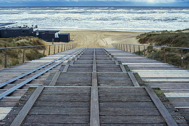 Steps down to Egmond aan Zee beach during a choppy North Sea.