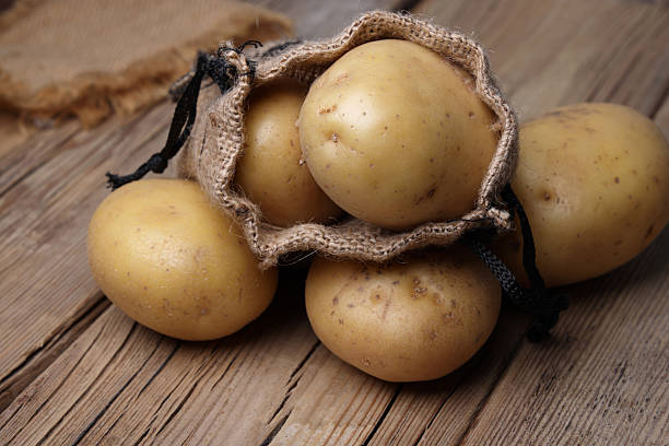 sale of new fresh potato crop in nets on the shelves in the store
