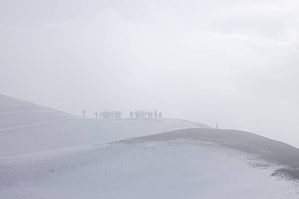 View of Mount Etna in Sicily with a guided tour group hiking along volcanic trails. Tourists explore the iconic volcano, enjoying scenic landscapes and volcanic features during an organized trekking adventure.