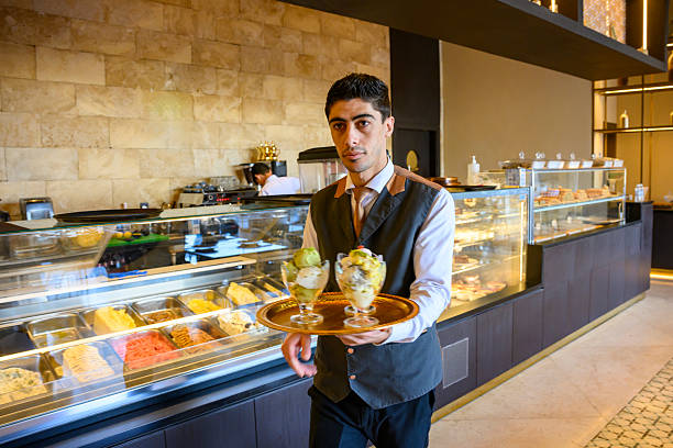 Waiter serving ice cream sundaes at a modern cafe