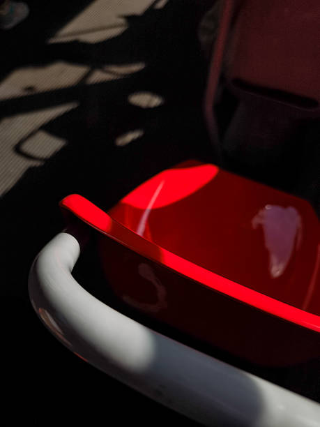 Shiny red and white seats are reflecting light and shadows, creating an abstract and colorful composition, perfect for backgrounds and design projects