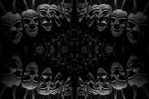 A mirrored, abstract composition of Lazarim wooden masks forms a dark, symmetrical pattern, creating a dramatic background of carved textures, shadows, and ritualistic expressions.