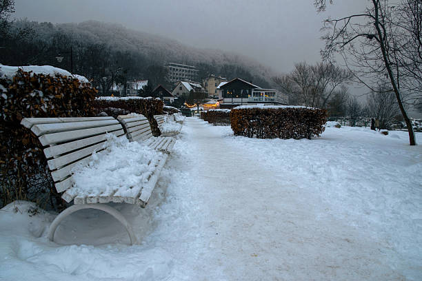 Park bench covered with snow and isolated on snow background.