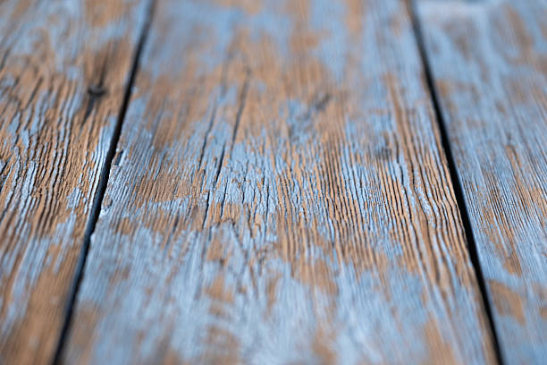 Old blue painted wooden surface with peeling paint and visible texture. Rustic vintage background with copy space for design.