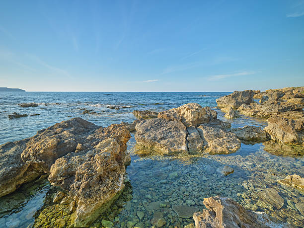 A rocky coastline with sunshine, blue sky and crystal clear water  - Crete,  Greece, Mediterranean Sea