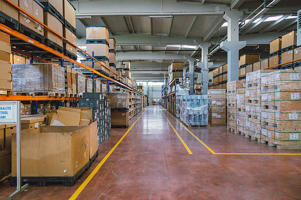 Rows of many shelves with cardboard boxes in storage room of huge distribution warehouse aisle in industrial storage factory background XXXL size