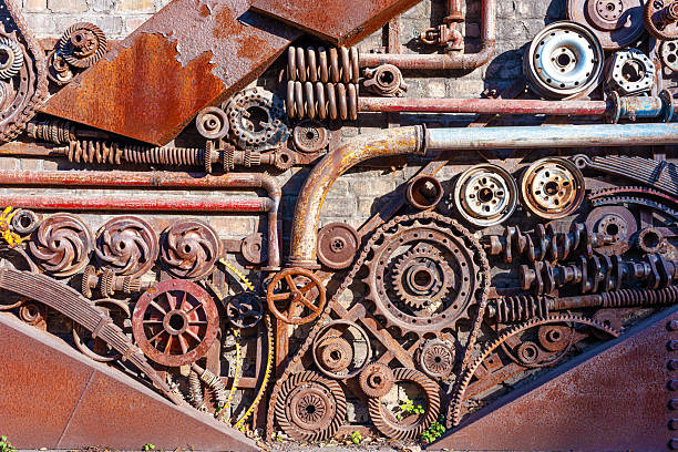 Rusty mechanical metal parts are displayed on the brick wall