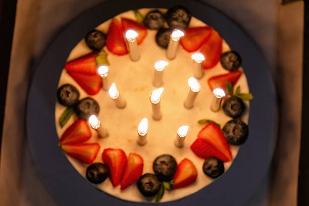 Woman is holding birthday cake.