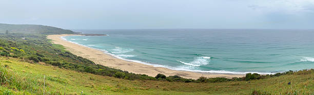 Praia de São Rafael, a beach flanked by cliffs with isolated rocks on the sand and others jutting out of the sea (9 shots stitched)
