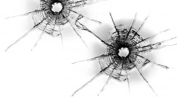 istock Shattered glass with two bullet holes on white background, creating dramatic and intense visual effect 2261196306