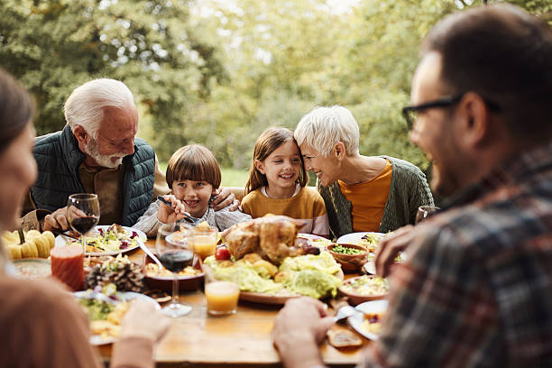 Happy extended family talking during a meal in nature.