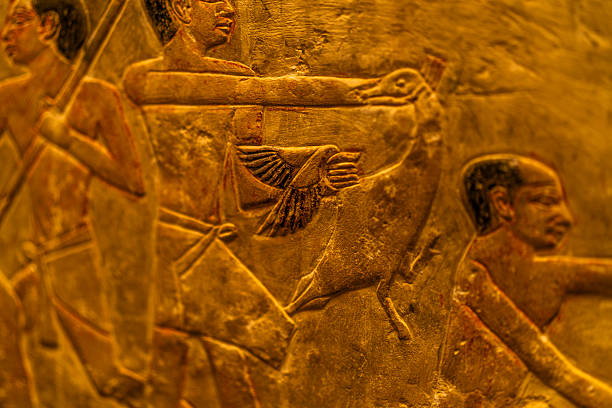 Close up of ancient Egyptian stone relief showing carved human figures on a temple wall in Cairo, Egypt, highlighting texture, craftsmanship, heritage, and historical continuity.