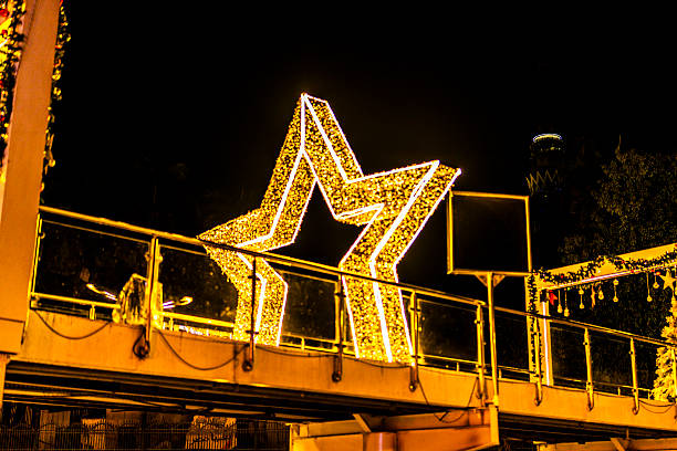 Bright illuminated star decoration on an urban bridge at night in Cairo, Egypt, creating a festive atmosphere with glowing lights, city elements, and modern public space design.