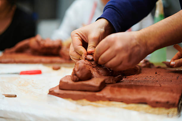 Artist working on clay sculpture in art studio