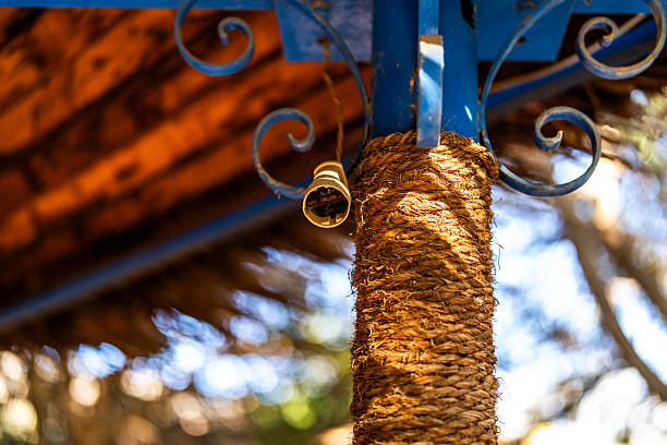 Close up of a rope wrapped column supporting an outdoor structure in Giza, Egypt, with warm light and soft background blur highlighting texture, craftsmanship, and rustic design.