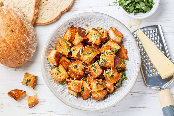 Croutons with herbs, garlic and cheese from white bread or baguette. Served for salad or soup. Selective focus, top view